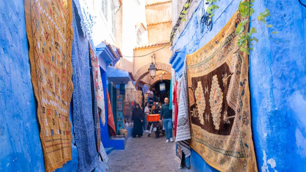 Colorful rugs in blue alleyway